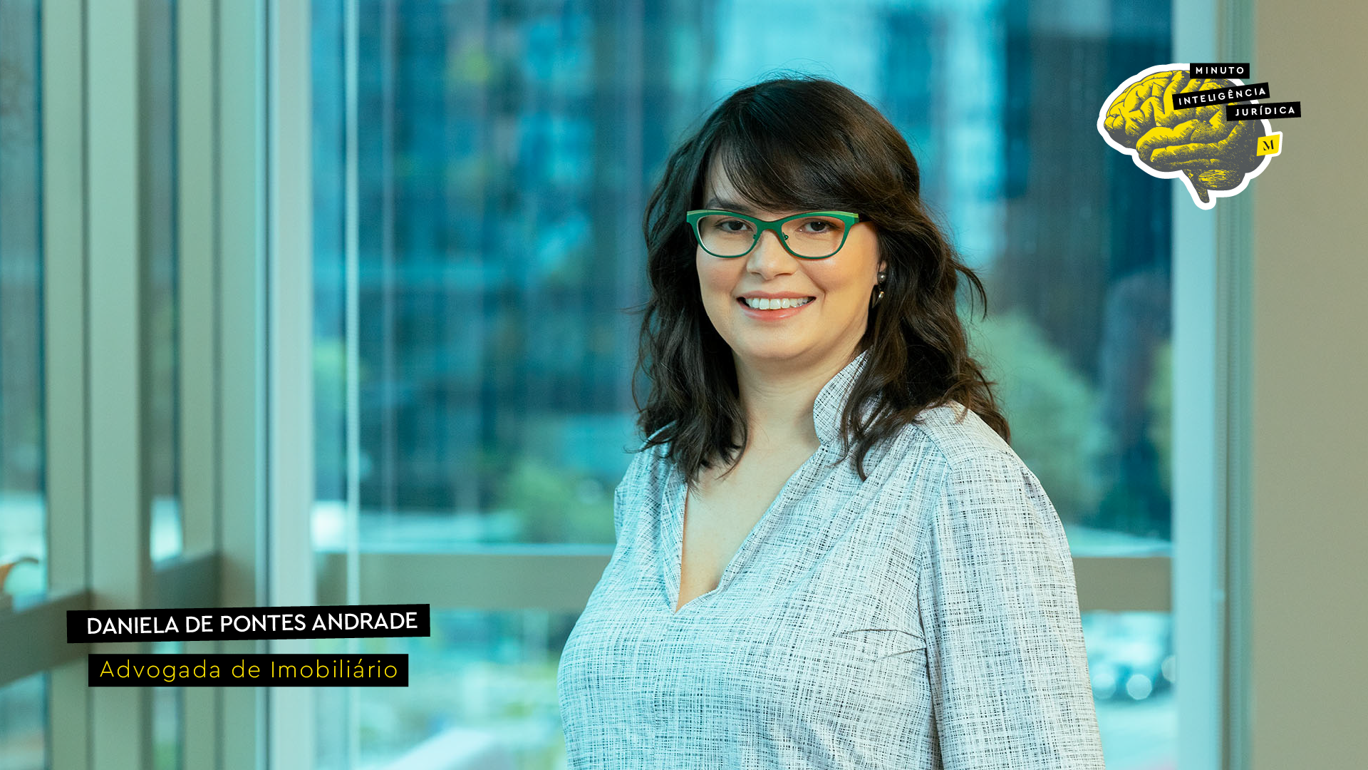 Mulher olhando para a foto e sorrindo, com cabelo preto e franja, usando camisa cinza e óculos de grau verde. No canto inferior esquerdo, frase com os dizeres "Daniela de Pontes Andrade - Advogada de imobiliário". No canto superior direito, logotipo do Inteligência Jurídica