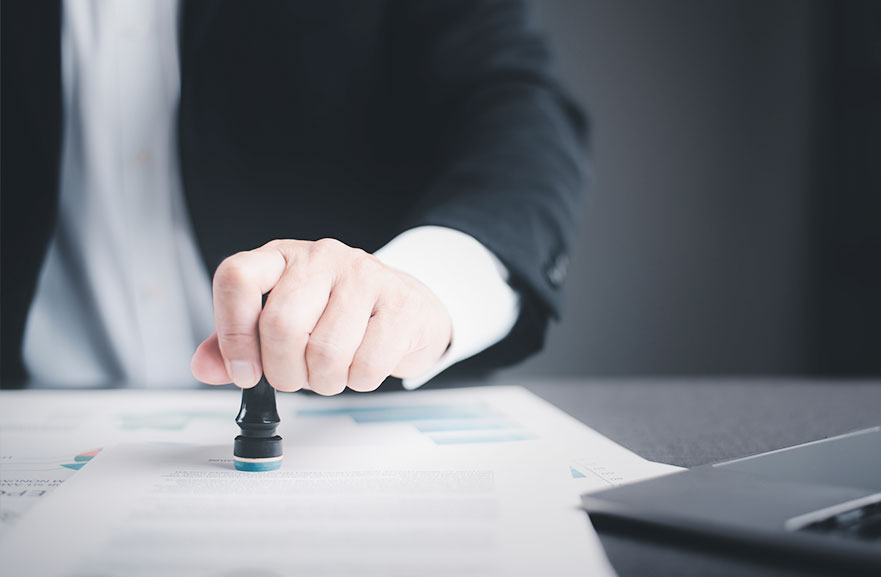 Business person stamp on the contract documents on the desk, the concept of contract confirmation or approval, the authority to authorize solicitation.