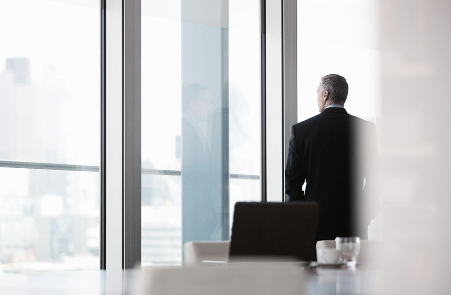 Empresário olhando janela da sala de conferência