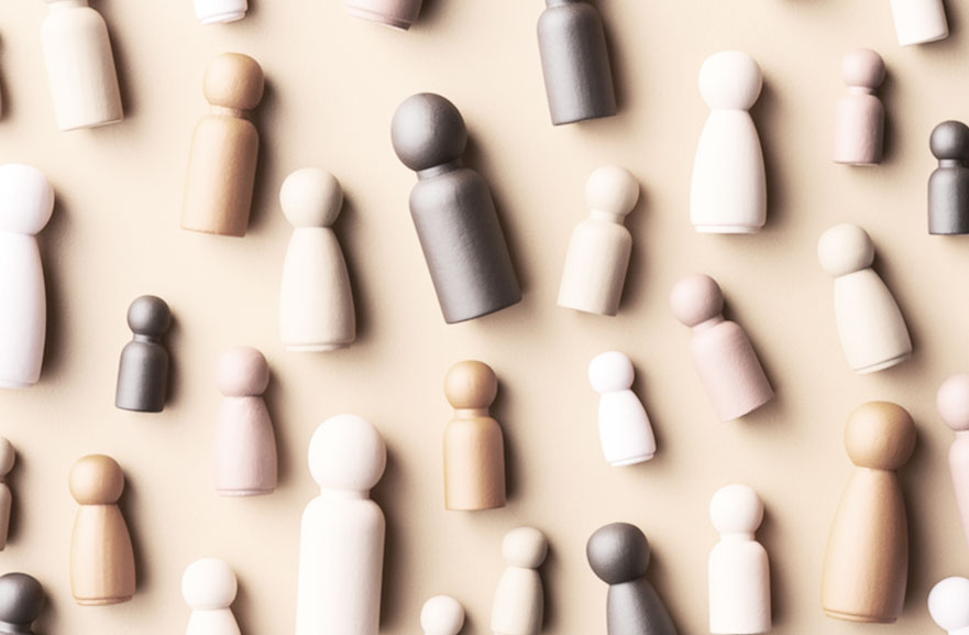 Peças de xadrez posicionadas lado a lado em cima de uma mesa, com variações de tons entre marrom, branco e beje