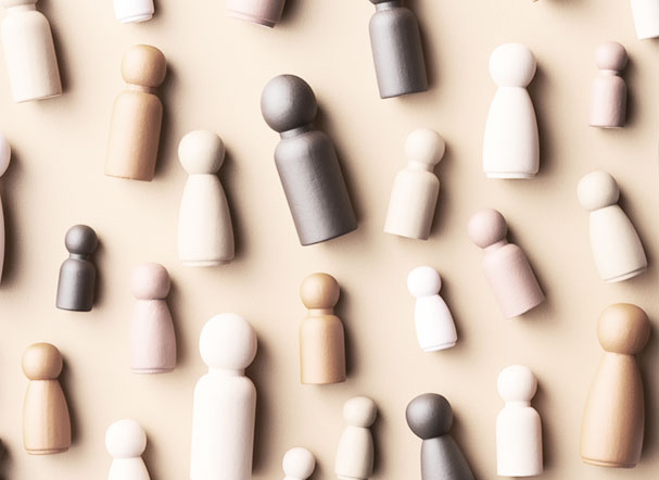 Peças de xadrez posicionadas lado a lado em cima de uma mesa, com variações de tons entre marrom, branco e beje