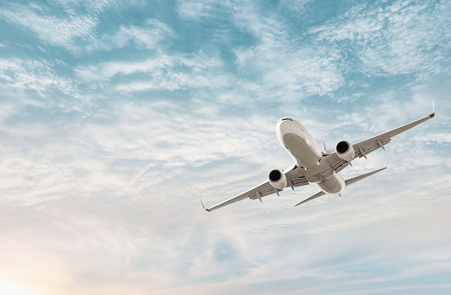 Visão inferior de aeronave branca sobrevoando o céu