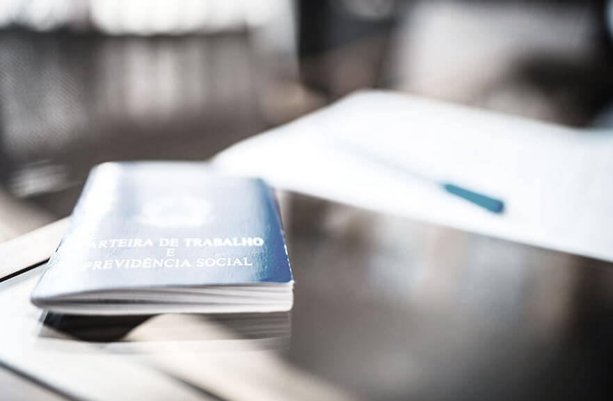 work permit on a glass table. Next to it, a blue pen above a white sheet of paper.