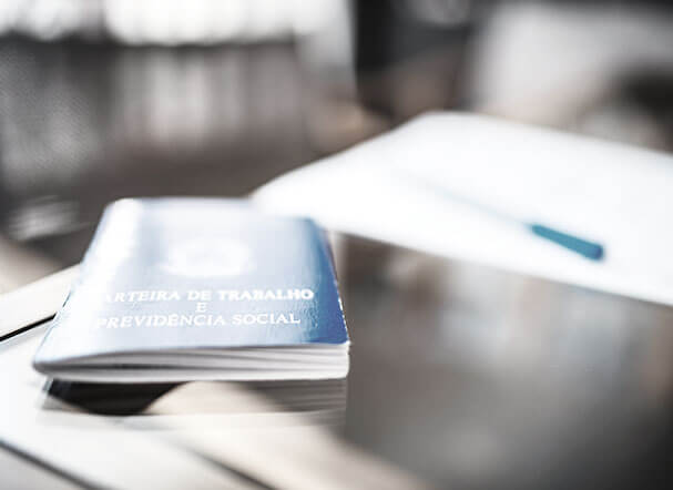 work permit on a glass table. Next to it, a blue pen above a white sheet of paper.