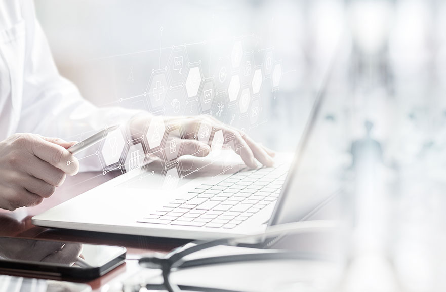 Pessoa teclando no notebook e segurando caneta em uma das mãos