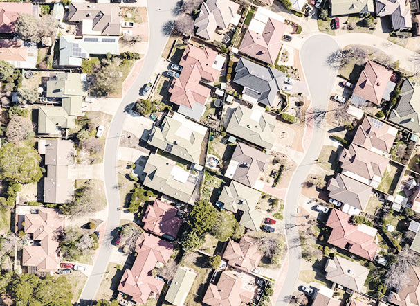 Visão superior de uma vila com várias casas, arbustos e ruas