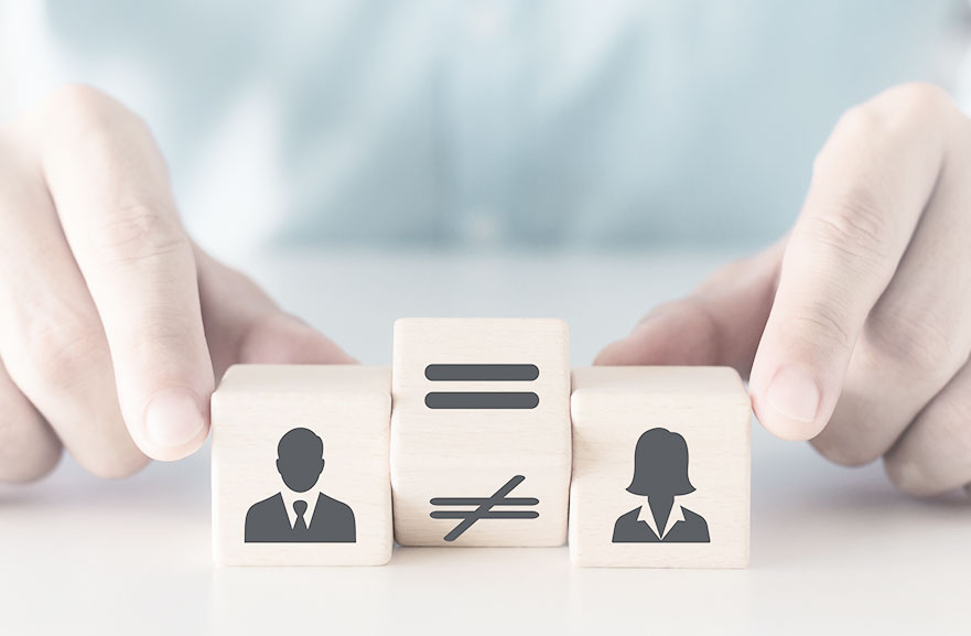 Concept of equal pay between men and women. Illustrative image of three wooden blocks: one representing men, positioned on the left side of the image, another representing women, positioned on the right side, and the middle block with the "equal" symbol highlighted
