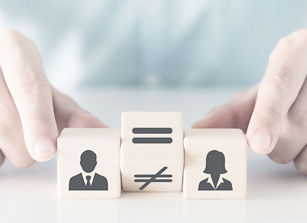 Concept of equal pay between men and women. Illustrative image of three wooden blocks: one representing men, positioned on the left side of the image, another representing women, positioned on the right side, and the middle block with the "equal" symbol highlighted