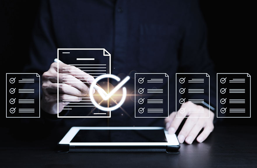 Representação gráfica de elementos representando documentos saindo de um tablet branco. Ao fundo, pessoa usando camisa social preta e com uma caneta branca em uma das mãos.