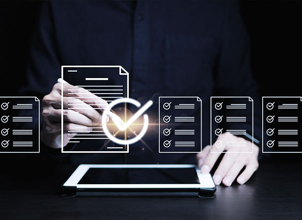 Graphic representation of elements representing documents coming out of a white tablet. In the background, a person wearing a black dress shirt with a white pen in one hand.