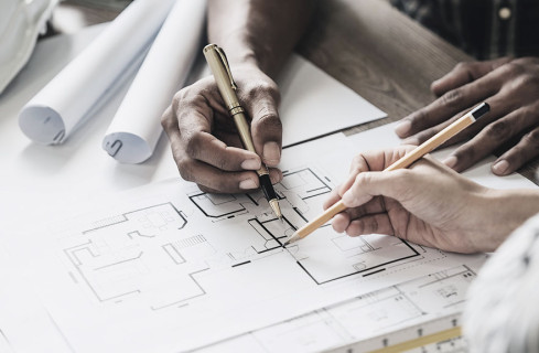 visão superior de duas pessoas desenhando projeto arquitetônico