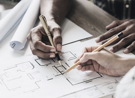 visão superior de duas pessoas desenhando projeto arquitetônico