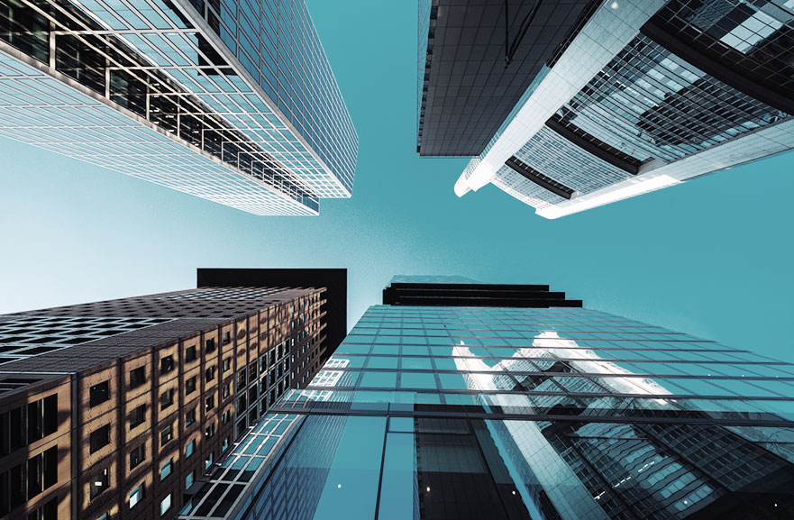 Visão inferior de cinco prédios espelhados, com cores diferentes e posicionados um ao lado do outro