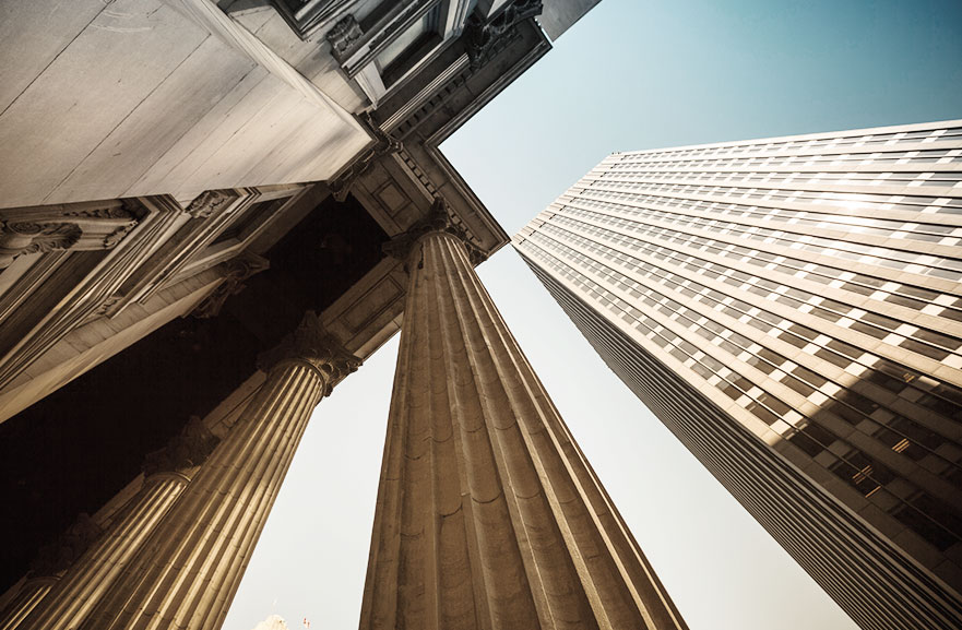 Visão inferior de prédio com estrutura de concreto e dois pilares de sustentação