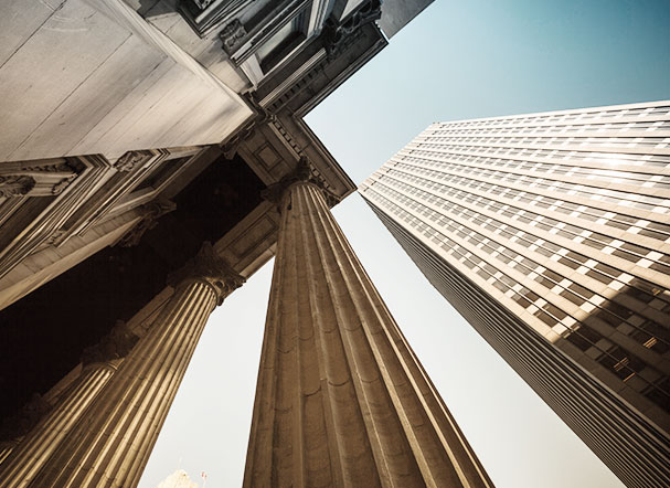 Visão inferior de prédio com estrutura de concreto e dois pilares de sustentação