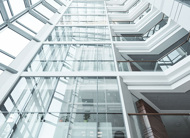 Bottom view of building with white iron structure and glass windows