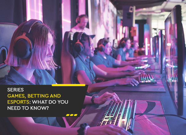 Several people sitting side by side, wearing headphones and identical computers in an online gaming competition