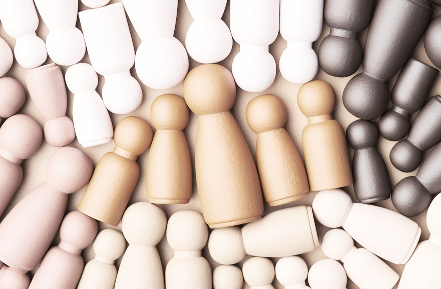 Peças de xadrez posicionadas lado a lado em cima de uma mesa, com variações de tons entre marrom, branco e beje