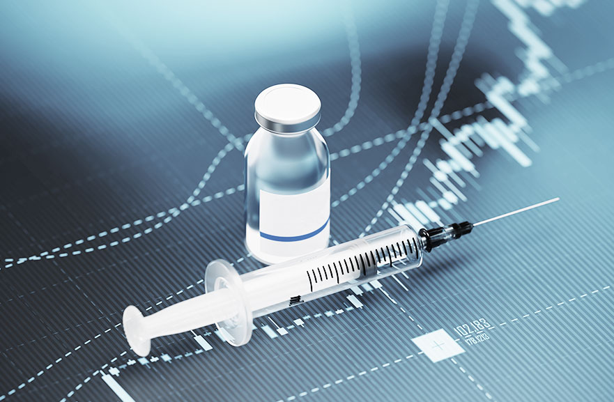 Ampola transparente de vidro com substância liquida, ao lado de uma seringa plástica transparente