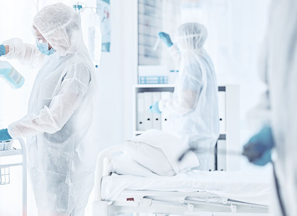 Pessoas usando uniforme hospitalar e trabalhando em laboratório