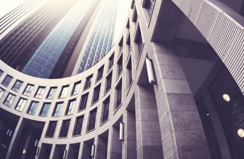 Visão inferior de edifício com estrutura ondulada, com paredes da cor marrom e várias janelas