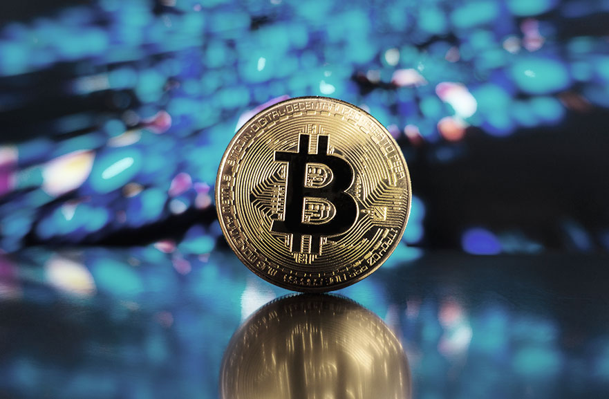 Ilustração de moeda dourada com o símbolo do bitcoin estampado em preto