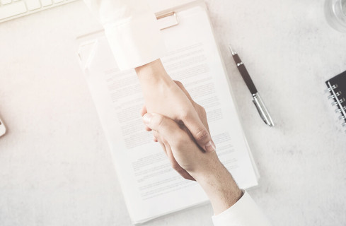 Duas pessoas fechando uma negociação de contrato