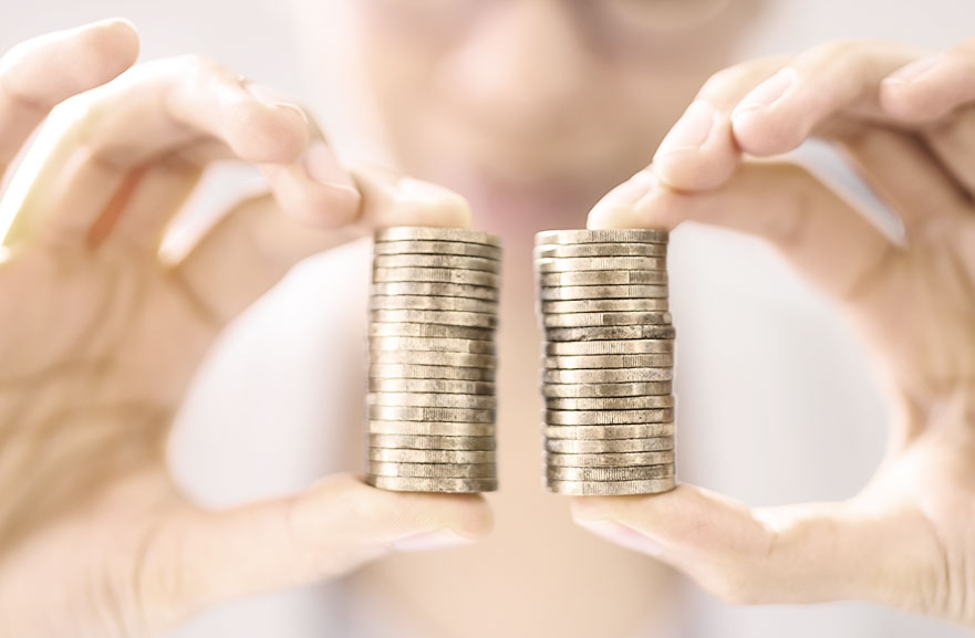 Pessoa segurando duas pilhas iguais de moedas douradas