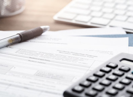 Imagem de calculadora, folha A4 e caneta