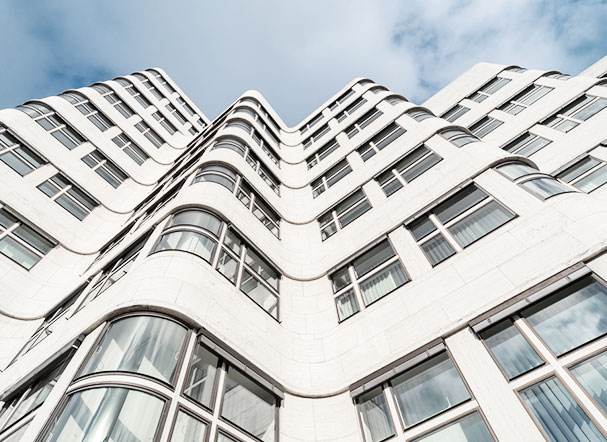 Bottom view of corrugated-frame building with brown-colored walls and multiple windows