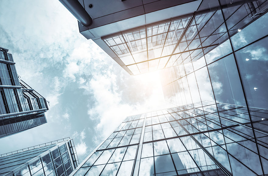 Lower view of mirrored building with sky in the background