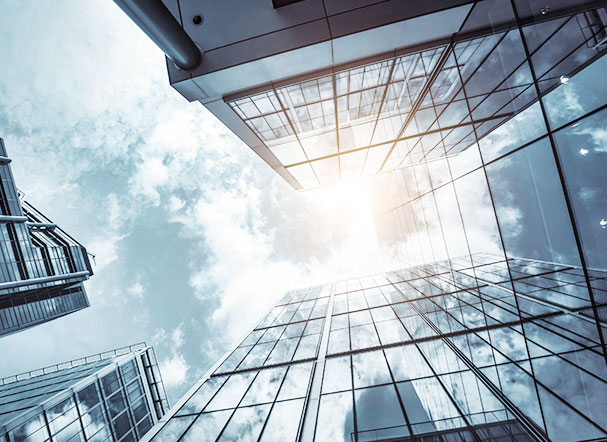 Lower view of mirrored building with sky in the background