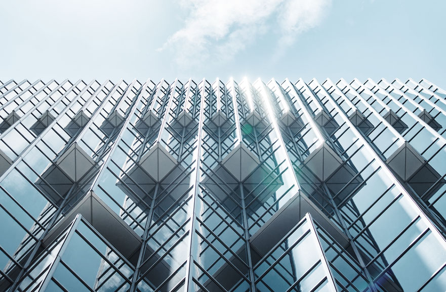 Bottom view of metal-framed building with mirrored glass windows