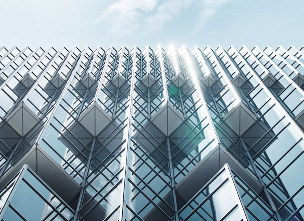 Bottom view of metal-framed building with mirrored glass windows