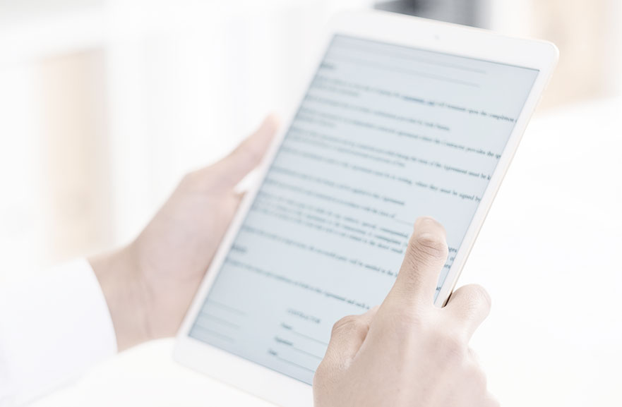 Foto em aspecto de fundo branco e mãos segurando tablet branco. 