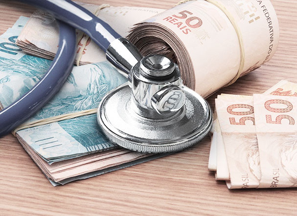 Money cake with 100 and 50 real notes, below a silver stethoscope with a navy blue cord